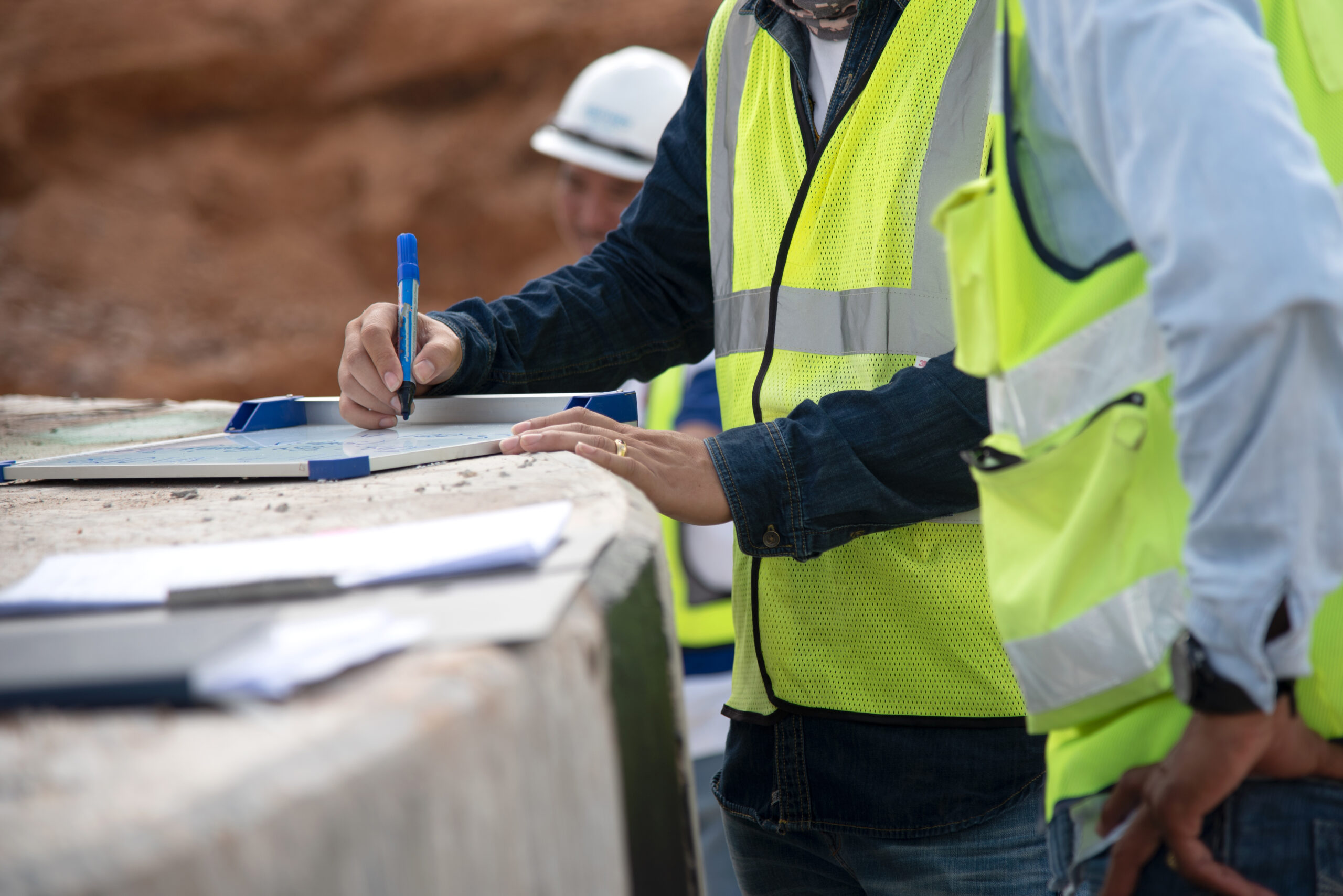 Técnicos de construcción revisando planos y documentación durante la planificación y supervisión de una obra.